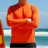 Orange long-sleeve shirt with blue accents on a gray surface